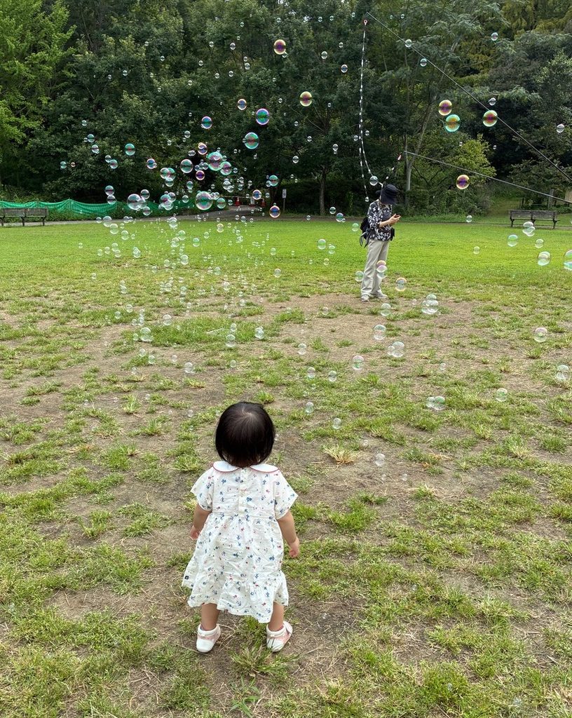 1歳の子どもがシャボン玉を眺める写真